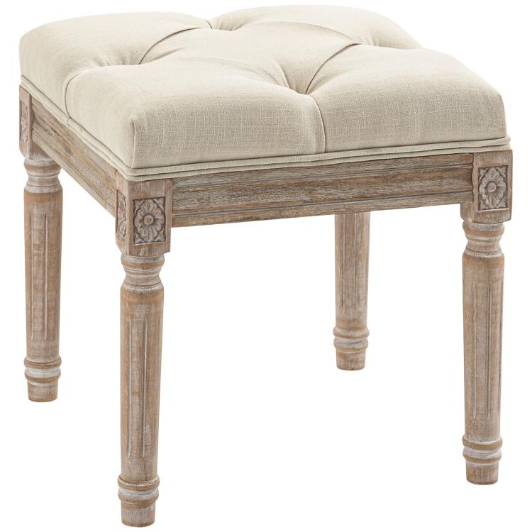 Beige upholstered ottoman footrest with tufted seat and carved wooden legs, corner accents