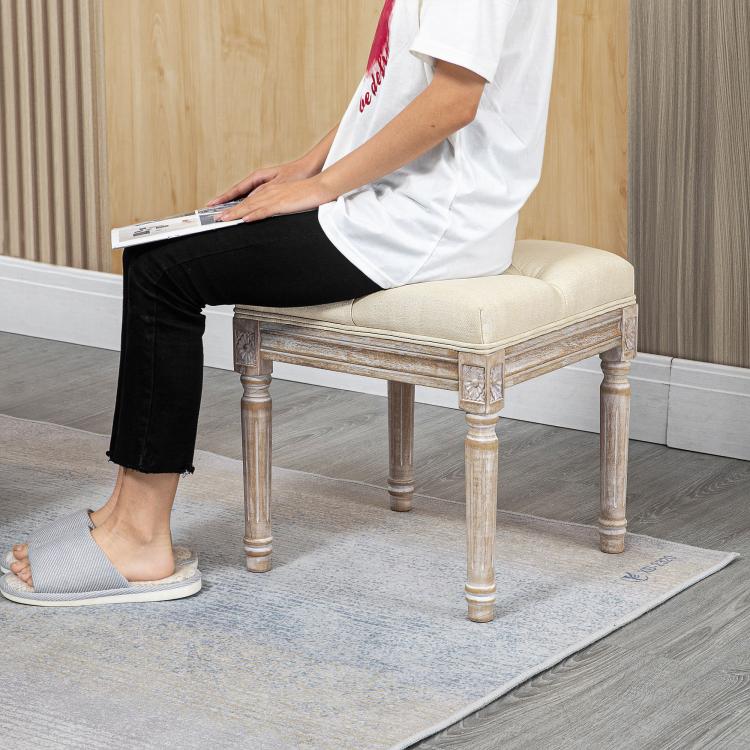 Beige ottoman bench footrest with tufted cushion and carved wooden legs