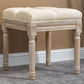 Beige upholstered ottoman bench with button-tufted seat and carved wooden legs