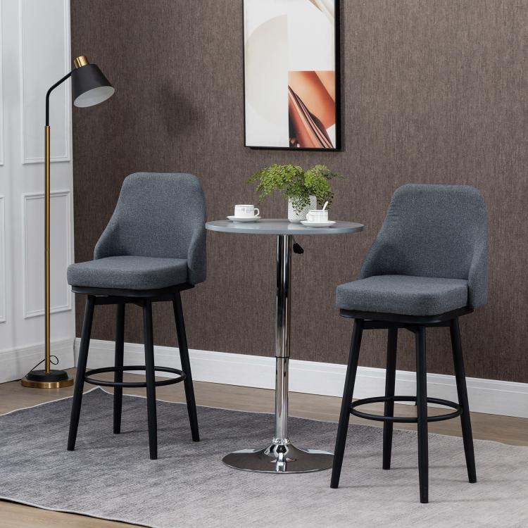 Dark gray upholstered bar stool set with round footrest and tapered black legs
