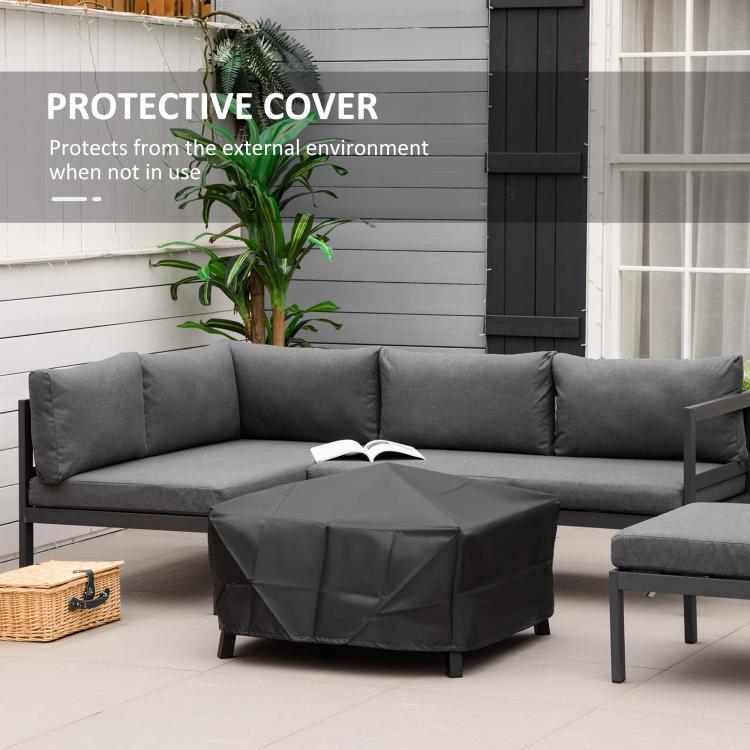 Black fire pit protective cover draped over grill table