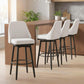 Set of 2 cream bar stools with padded seats, black legs, and circular footrests