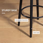 Black steel bar stool legs with circular footrest under a cream upholstered seat