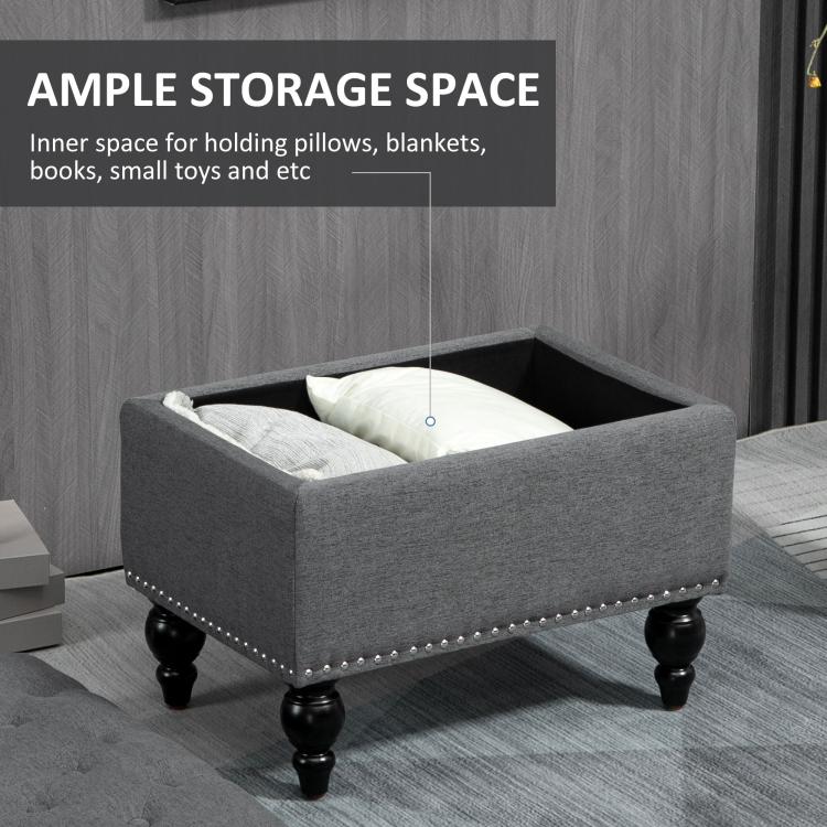 Gray storage ottoman with hinged lid open, interior storage space, studded trim