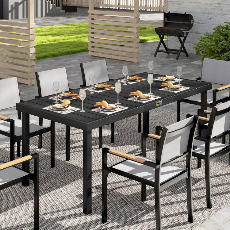 Outdoor dining table with black slatted tabletop and metal legs with chairs