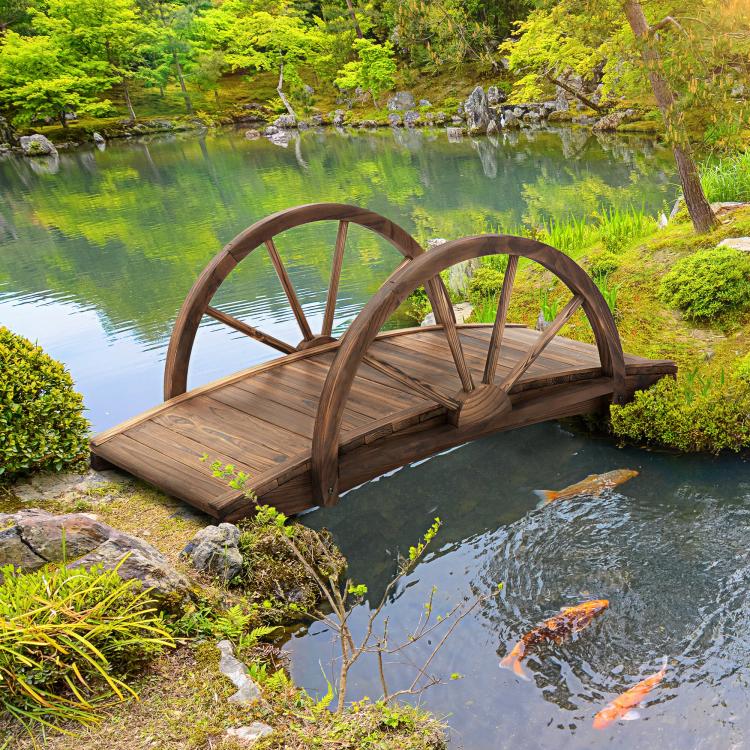 Stained wooden garden footbridge spanning a pond with wheel-style arched railings