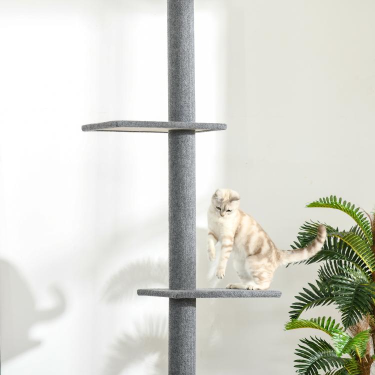 Gray cat climbing tower with round platforms and hanging scratching post; cat on mid shelf
