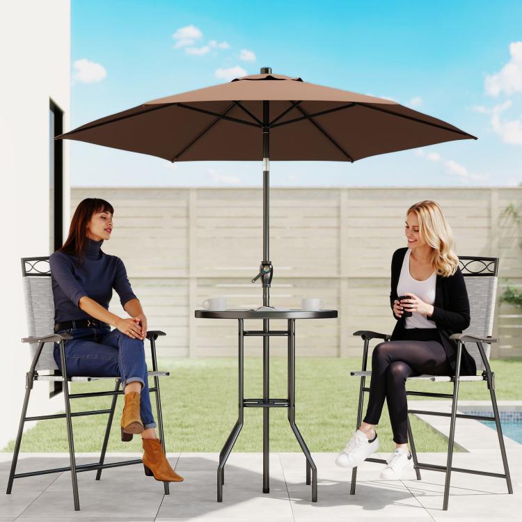 Outdoor patio bar set with brown umbrella and round table between two folding chairs