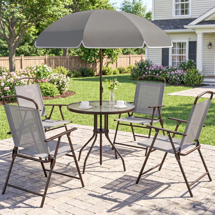 Gray patio dining set with umbrella over round glass table and four folding mesh chairs