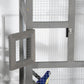 Grey outdoor bird cage with wire mesh, side door open on wooden frame