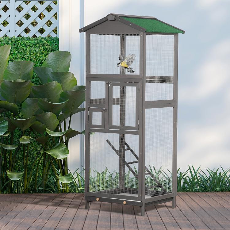Grey wooden bird aviary house with green roof and wire panels, bird perched inside