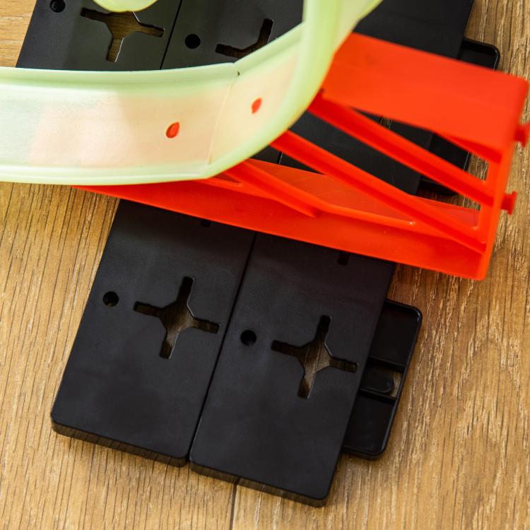 Kids race track loop kit with glowing lime rails and black spider base pieces