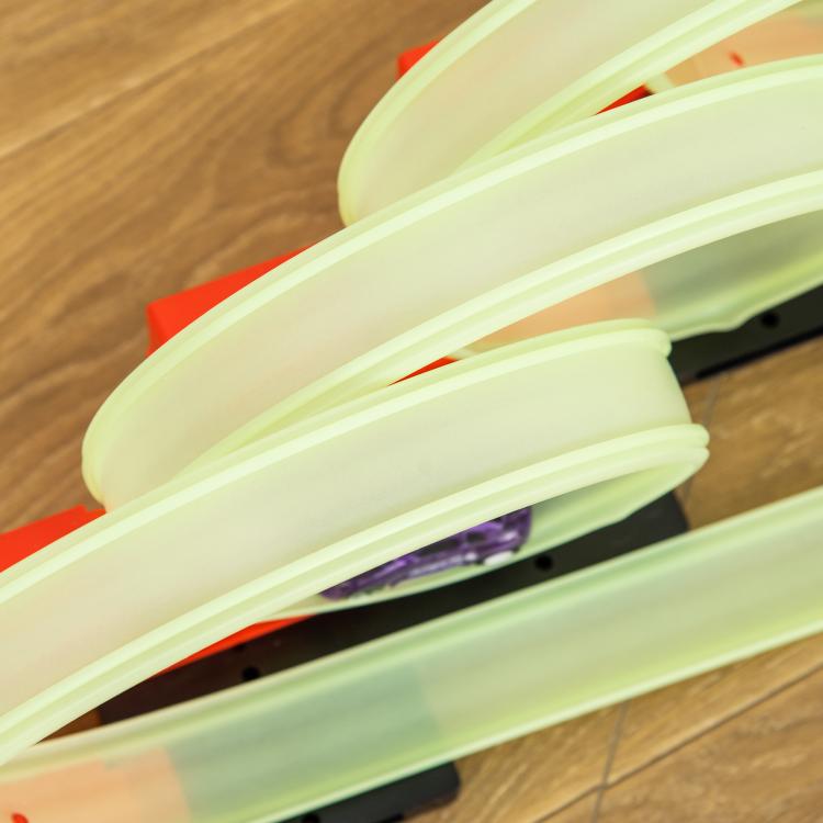 Close-up of glowing lime green track rails and loop section