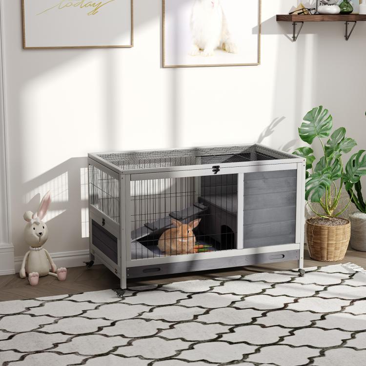 Indoor elevated wooden rabbit hutch with wire mesh sides and hinged dark door panel