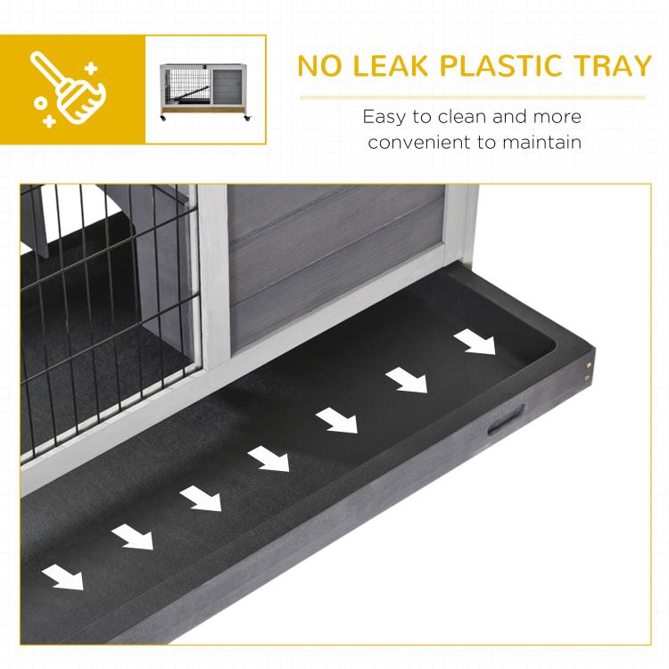 Wooden hutch with dark plastic tray under wire pen for easier cleaning