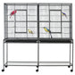 Bird cage with rolling base, wire enclosure and wooden perches, two colorful birds inside