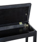 Black piano bench with hinged lid and padded faux-leather top