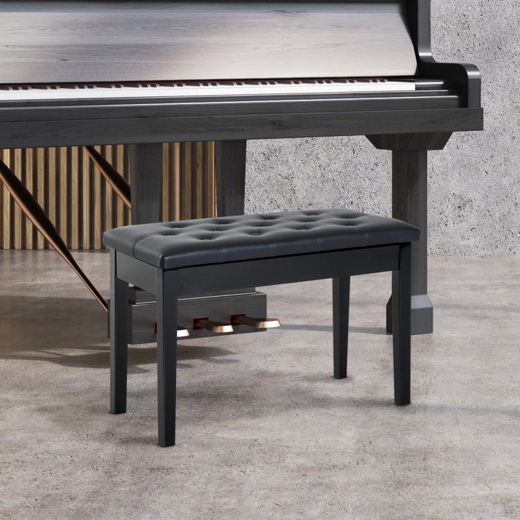 Black padded piano bench with tufted seat and four tapered wooden legs