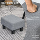 Gray padded ottoman foot rest with thick fabric cushion and black legs