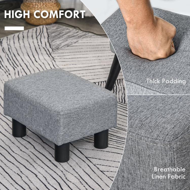 Gray padded ottoman foot rest with thick fabric cushion and black legs