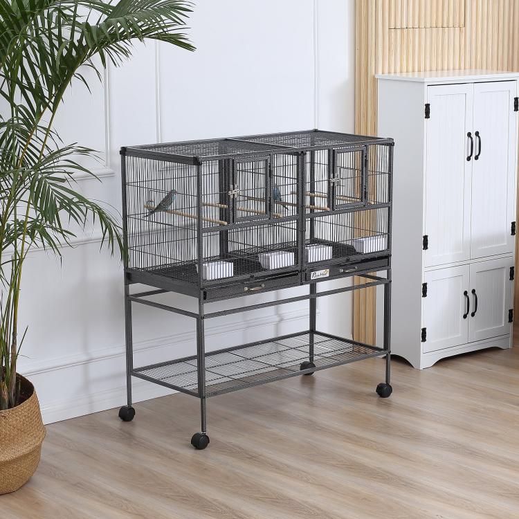Divided metal bird cage on wheeled stand with double doors and wood perches