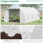 White tunnel greenhouse on outdoor ground with zippered door and mesh windows