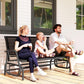 Outdoor glider bench with dark mesh back and black metal frame on wooden deck