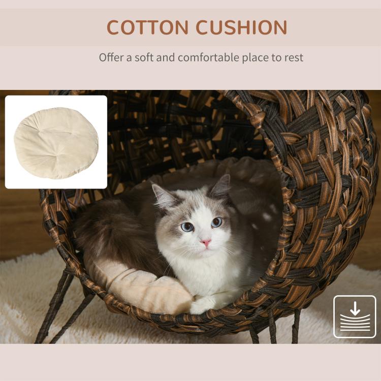 Woven cat bed with soft cotton cream cushion, cat lounging inside