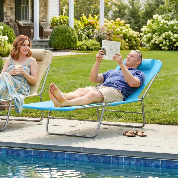 Blue chaise lounge chair with pillow and reclining back near a swimming pool
