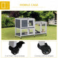 Rabbit hutch on rolling wheels with two enclosed levels, white frame and wire mesh doors