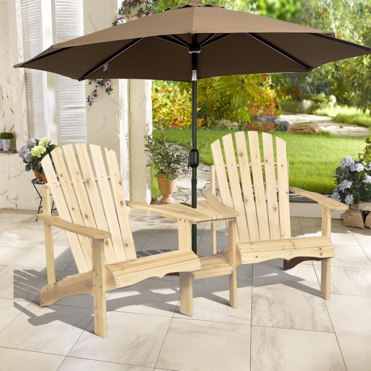 Natural wood two-person Adirondack bench with black umbrella and two slatted chairs.