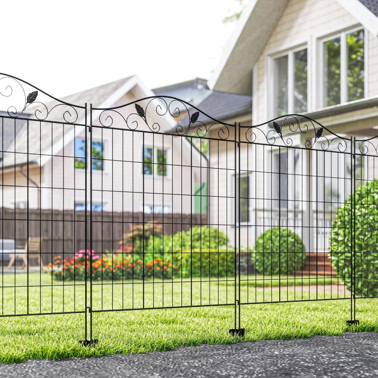 Installed black metal folding garden fence with scroll top and pointed ground stakes