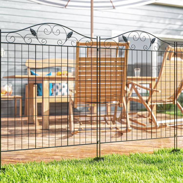 Black metal folding garden fence along patio walkway with scrollwork top