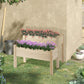 Two-tier raised wooden planter bed with pink flowering plants in yard