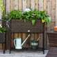Brown rattan-style wicker planter box with black legs and lower storage shelf