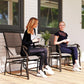 Two patio rocking chairs with brown sling backs and seats beside a small coffee table