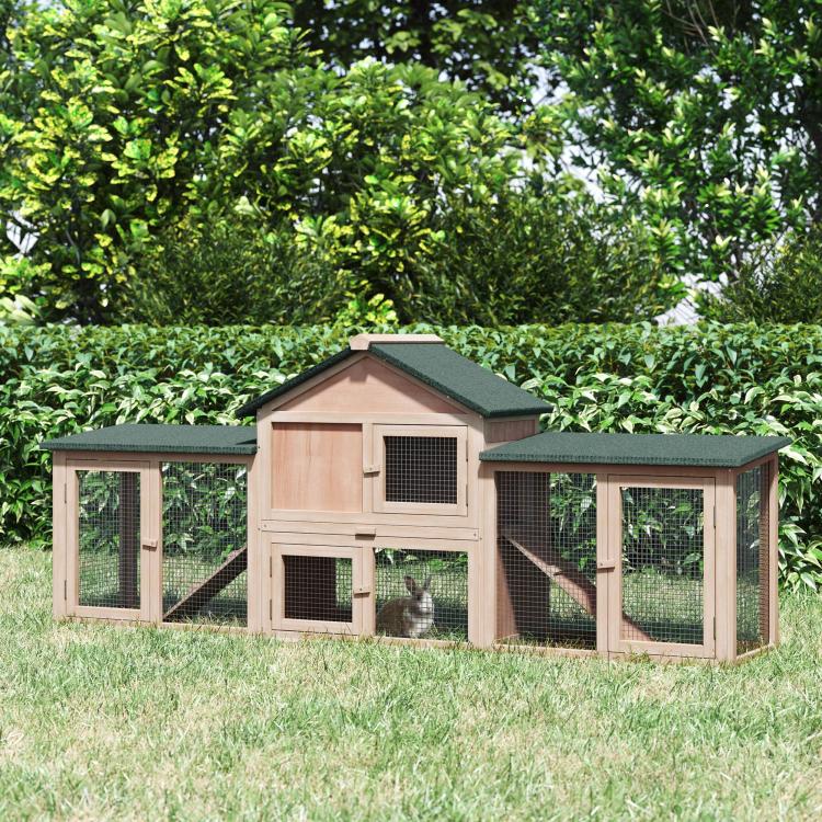 Two-story wooden rabbit hutch with fenced side runs and green roof