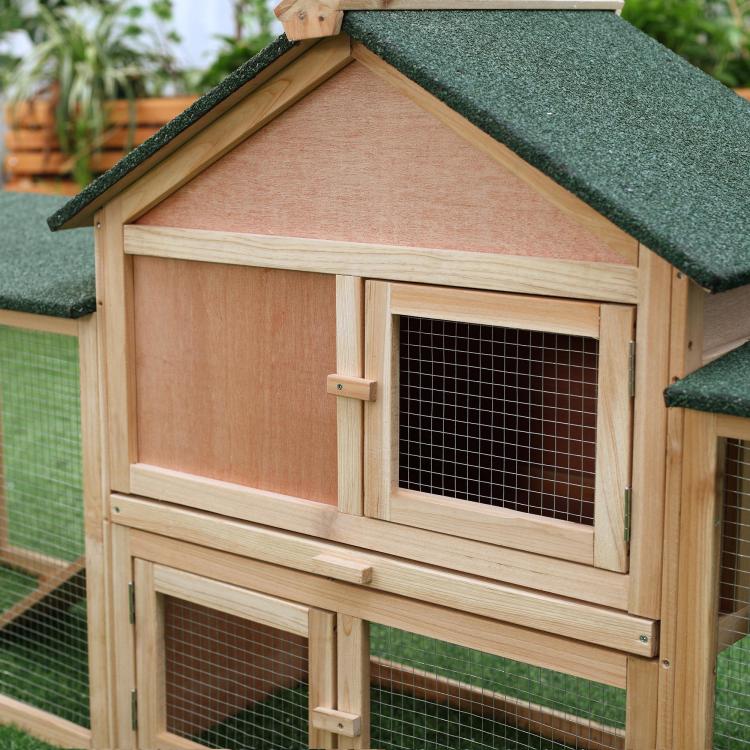 Wooden rabbit hutch front with mesh door and green shingle roof