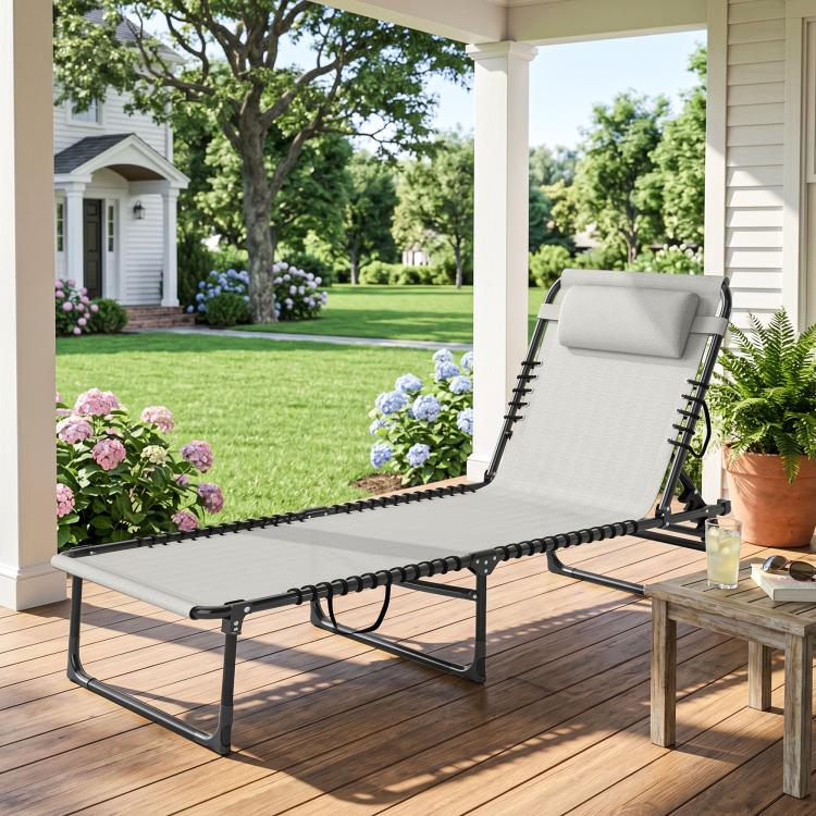 Cream folding chaise lounge pool chair with pillow and ventilated mesh seat on a wooden deck