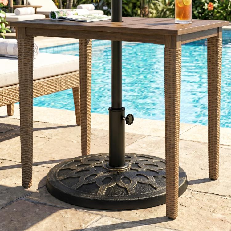 Black umbrella base stand with decorative round base holding a patio umbrella pole