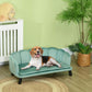 Green upholstered pet sofa bed with padded seat and tufted back, dark wood legs