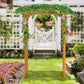 Outdoor wooden arbor trellis with lush green vines and pink flowers covering the arch