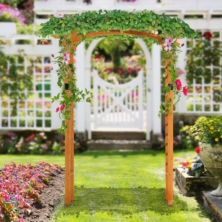 Outdoor wooden arbor trellis with lush green vines and pink flowers covering the arch