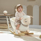 White plush rocking sheep with striped scarf; toddler sitting and holding on.