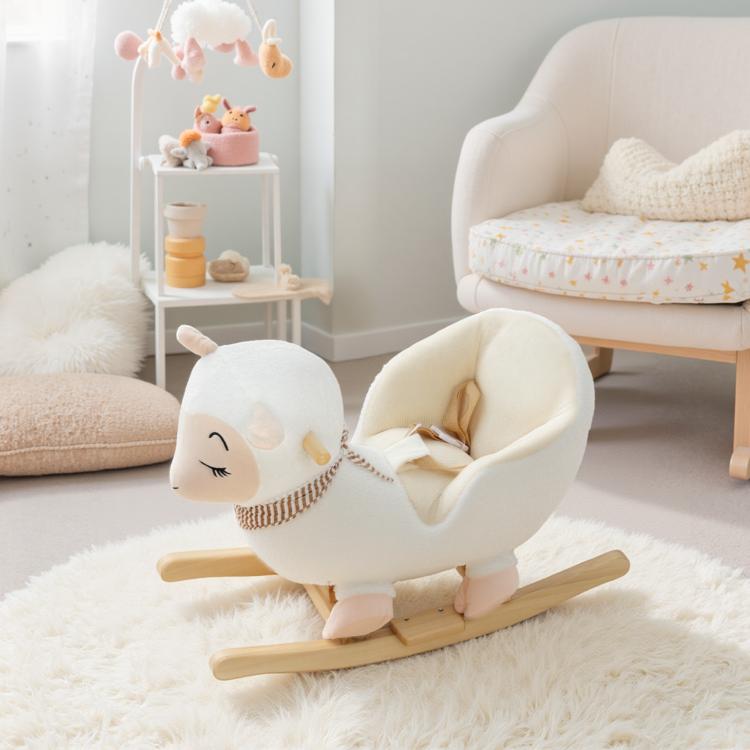 White plush rocking sheep toy with striped scarf on wooden rockers in a nursery.