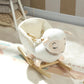 White plush rocking sheep toy with striped scarf and wooden rockers, angled view.