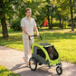 Green pet bike trailer stroller with mesh panels and visible dog inside, four wheels