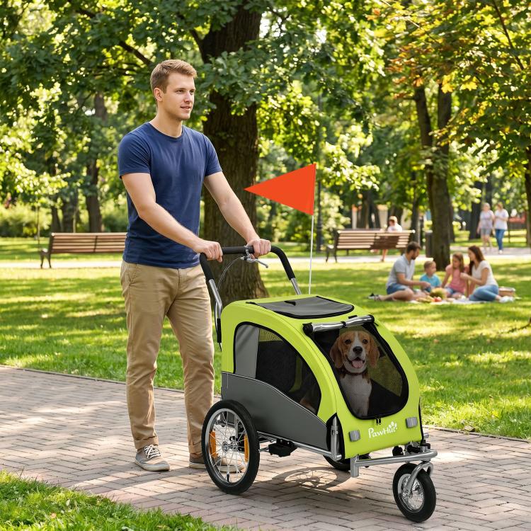 Green dog bike trailer with front mesh door and safety flag mounted on handle