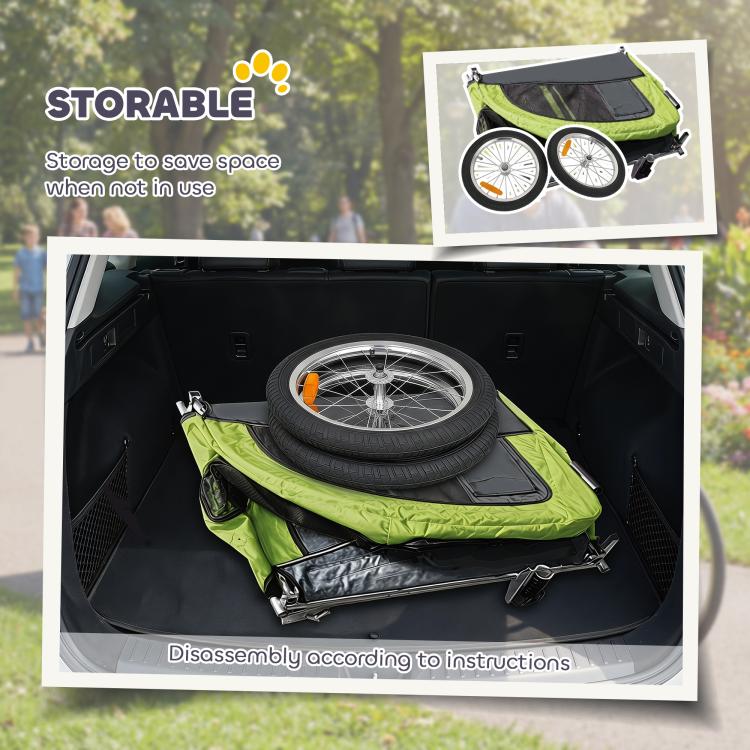 Green pet bike trailer with open storage compartment holding a folded accessory