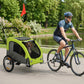 Green pet stroller trailer with mesh windows, towed behind a bicycle